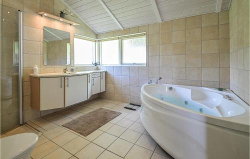 a bathroom with a tub and a sink and a toilet at 3 Bedroom Gorgeous Home In Askeby in Askeby