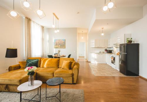 Una sala de estar con un sofá y una cocina. en Bearsleys Downtown Apartments, en Riga