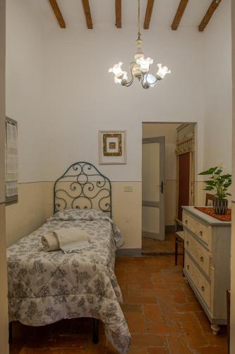 a bedroom with a bed and a dresser and a chandelier at Casa il Castello in Gambassi Terme