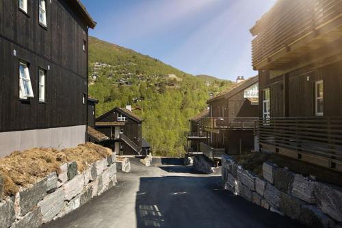 a street between two buildings with a mountain at Stranda Fjellgrend - with jacuzzi & 3 bedrooms in Stranda
