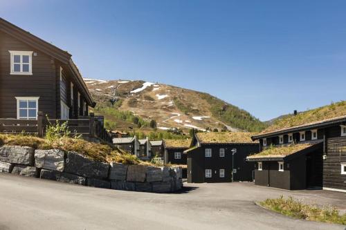 a row of houses with a mountain in the background at Stranda Fjellgrend - with jacuzzi & 3 bedrooms in Stranda