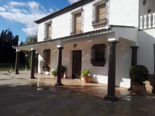 ein weißes Haus mit Säulen und Fenstern in der Unterkunft Casa Tita Carmen in Córdoba