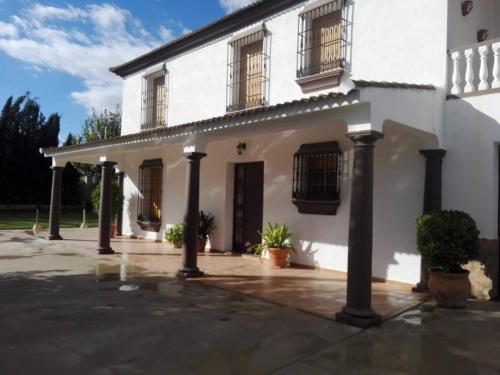 a white house with columns and windows at Casa Tita Carmen in Córdoba