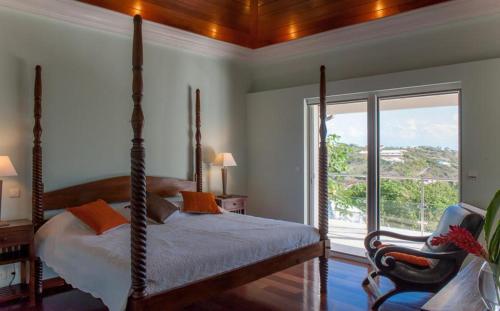 - une chambre avec un lit et une grande fenêtre dans l'établissement Luxury Vacation Villa 17, à Le Marigot