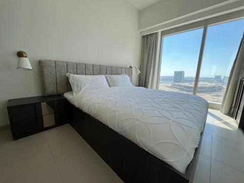 a bed in a room with a large window at Dinar Home in Abu Dhabi