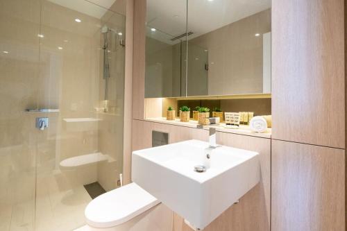 シドニーにあるContemporary 2-Bed Apartment Minutes to Cityのバスルーム(白い洗面台、トイレ付)