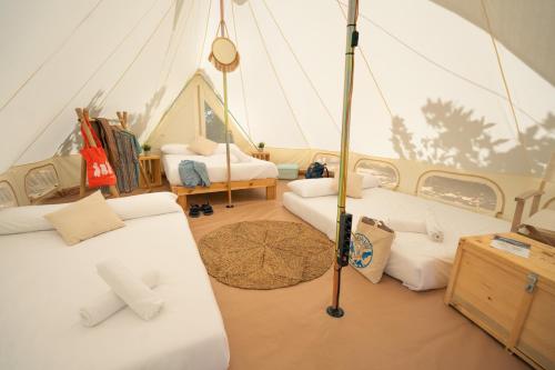 a room with two beds in a tent at Kampaoh Delta del Ebro in El Poblenou del Delta