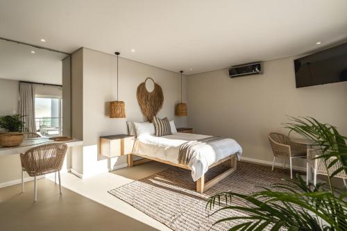 a bedroom with a bed and a table and chairs at View16 in Cape Town