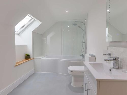 a white bathroom with a tub and a toilet and a sink at 5 Bed in Barnstaple 85165 in Charles