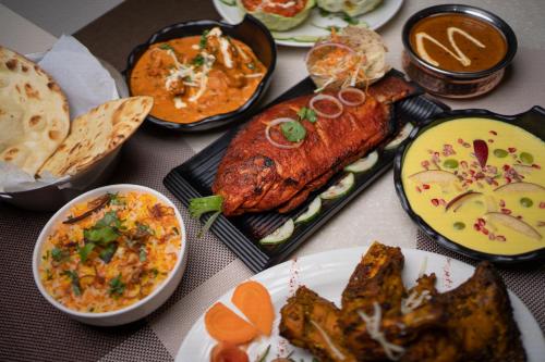 una mesa cubierta con diferentes tipos de comida en platos en Hotel Namlau, en Namsai