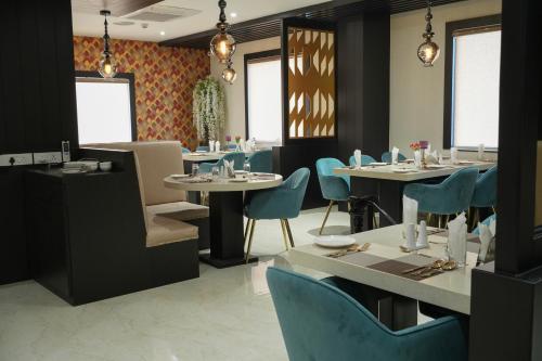 Namsai的住宿－Hotel Namlau，一间配备有桌子和蓝色椅子的用餐室