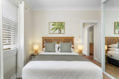 a bedroom with a large white bed with two lamps at Spacious 2-Bed Apartment in the heart of Manly in Sydney