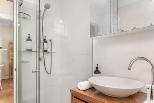 a white bathroom with a sink and a shower at Spacious 2-Bed Apartment in the heart of Manly in Sydney