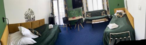 a room with two beds and a desk at Hotel Bella in Jelenia Góra
