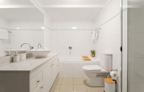 uma casa de banho branca com um WC e um lavatório em Bright and Modern Apartment in Amazing Location em Sydney