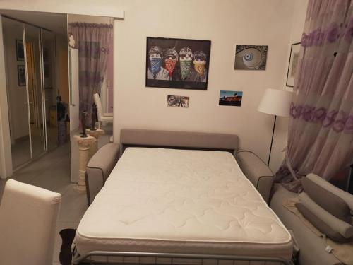 a white bed in a room with a couch at Focolare domestico in Milan