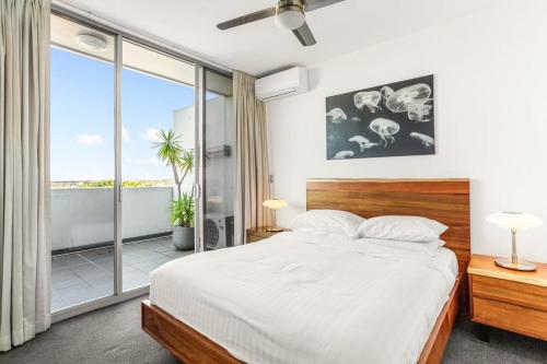 Spacious 2-Bed with Two Balconies with City Views في سيدني: غرفة نوم بسرير ونافذة كبيرة