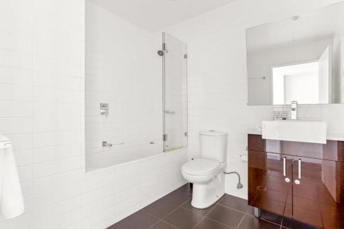 La salle de bains est pourvue de toilettes, d'une baignoire et d'un lavabo. dans l'établissement Spacious 2-Bed with Two Balconies with City Views, à Sydney