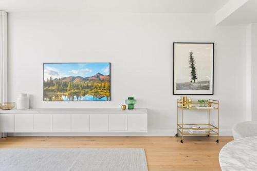 uma sala de estar branca com uma televisão numa parede branca em Boutique 2-Bed with Stunning Sydney Harbour Views em Sydney