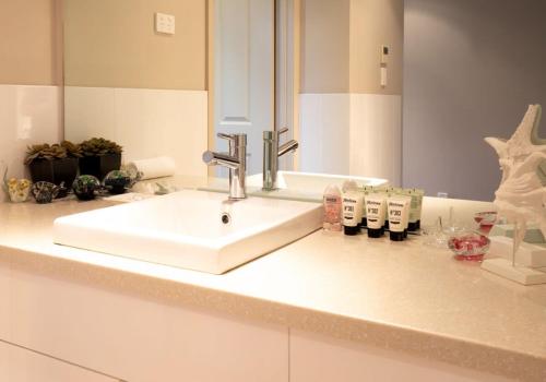 a bathroom counter with a sink and a mirror at Premium Views from Spacious Beachside Home in Batemans Bay