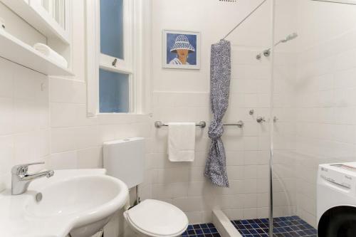 uma casa de banho com um WC, um lavatório e um chuveiro em Art Deco Apartment Meters Away From The Beach em Sydney