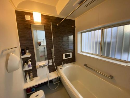 北九州市にあるH&H - Vacation STAY 14242のバスルーム(バスタブ、トイレ付)、窓が備わります。