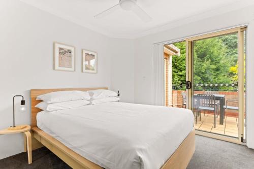 a bedroom with a bed and a sliding glass door at Pristine 2-Bed Near Marrickville Village in Sydney
