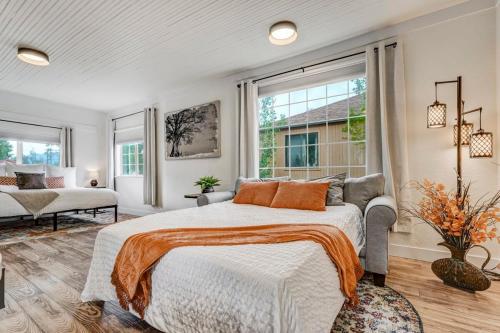 a bedroom with a bed and a couch and windows at Del Norte Cottage - Downtown King BBQ Fire Pit in Colorado Springs