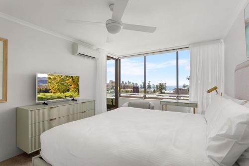una camera bianca con un grande letto e finestre di Elegant 2-Bed Unit with Expansive Harbour Views a Sydney