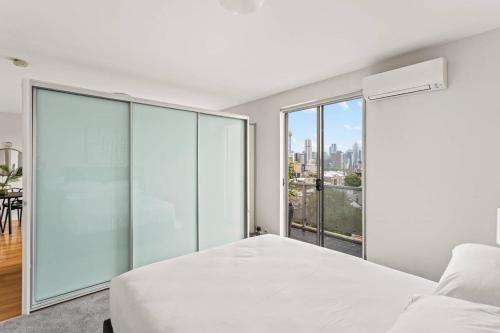 a bedroom with a white bed and a large window at Executive 1-Bed Apartment with City Views in Sydney