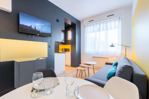 - un salon avec un canapé et une table avec des verres à vin dans l'établissement Marcq-en-Baroeul - App art deco equipped for 2!, à Marcq-en-Barœul