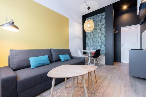 een woonkamer met een bank en een tafel bij Marcq-en-Baroeul - App art deco equipped for 2! in Marcq-en-Baroeul