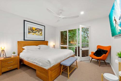 1 dormitorio con 1 cama, 1 silla y 1 ventana en Leafy Retreat with Deck & City Convenience, en Sídney