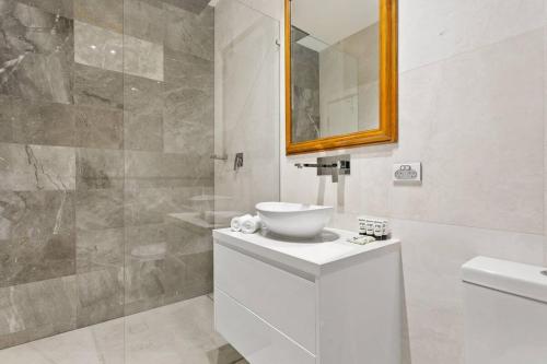 a bathroom with a sink and a toilet and a mirror at Traditional 2-Bed Terrace House in Millers Point in Sydney