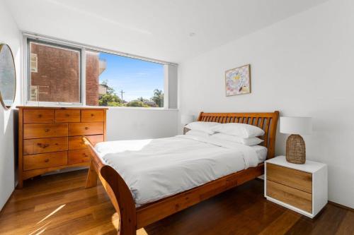 een slaapkamer met een bed, een dressoir en een raam bij Beautiful Boho 3-Bed by the Beach & the Bush in Sydney