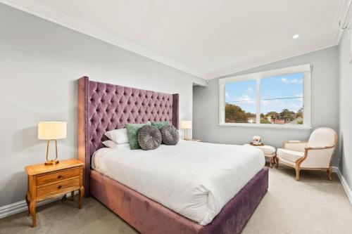 a bedroom with a large bed and a window at Impeccably Chic 4-Bed Home with Spa & Pool in Sydney