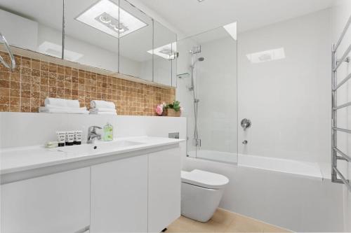 y baño con lavabo blanco y ducha. en Stunning double-story waterfront retreat, en Sídney