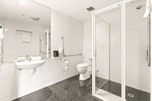 a bathroom with a toilet and a sink and a shower at Sleek 1-Bed by Jubilee Park with Rooftop Pool in Sydney