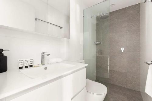 Modern 1-Bed Pad Minutes Away from Coogee Beach في سيدني: حمام أبيض مع حوض ومرحاض