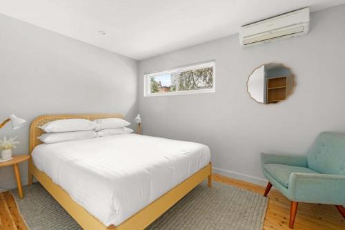 Modern 1-Bed Pad Minutes Away from Coogee Beach في سيدني: غرفة نوم بسرير وكرسي ازرق