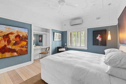 a bedroom with a large white bed and blue walls at Superb 2-Bed Apartment Facing Rose Bay Marina in Sydney