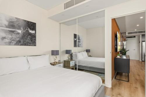 Un pat sau paturi într-o cameră la Modern 2-Bed: Quick to Beach & CBD