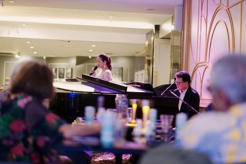 un hombre y una mujer tocando un piano en una habitación en Siam Mandarina Hotel - Free BKK Airport Shuttle en Lat Krabang