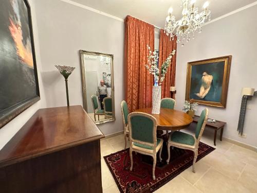 a dining room with a table and chairs and a mirror at Arts Club Suite & Spa in Chianciano Terme