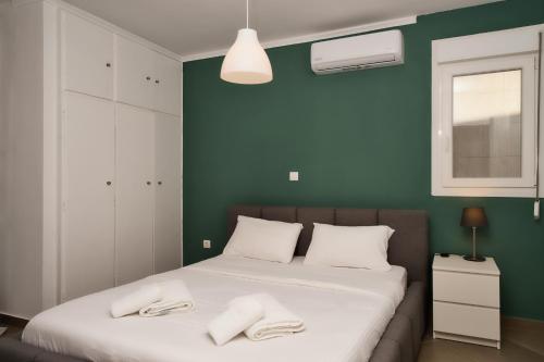 a bedroom with a bed with two towels on it at medusa apartment in glyfada in Athens