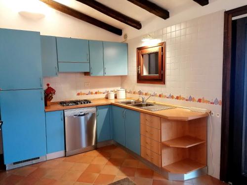 eine Küche mit blauen Schränken und einem Waschbecken in der Unterkunft Villetta delle Ginestre in Valle Dell’Erica