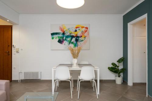 a dining room with a table and four chairs at medusa apartment in glyfada in Athens