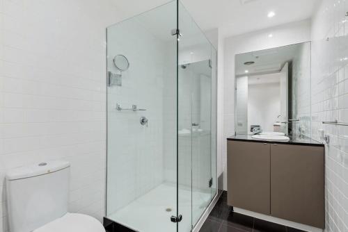 a bathroom with a shower and a toilet and a sink at Stylish and Spacious 2-Bed Apartment Melbourne in Melbourne