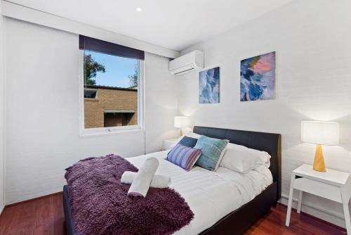 a bedroom with a large bed with a purple blanket at Central City Convenience in Prime Location in Melbourne