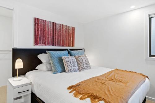 una camera bianca con letto e cuscini di Cozy 1-Bed Studio Near Cafes and Shops a Carnegie